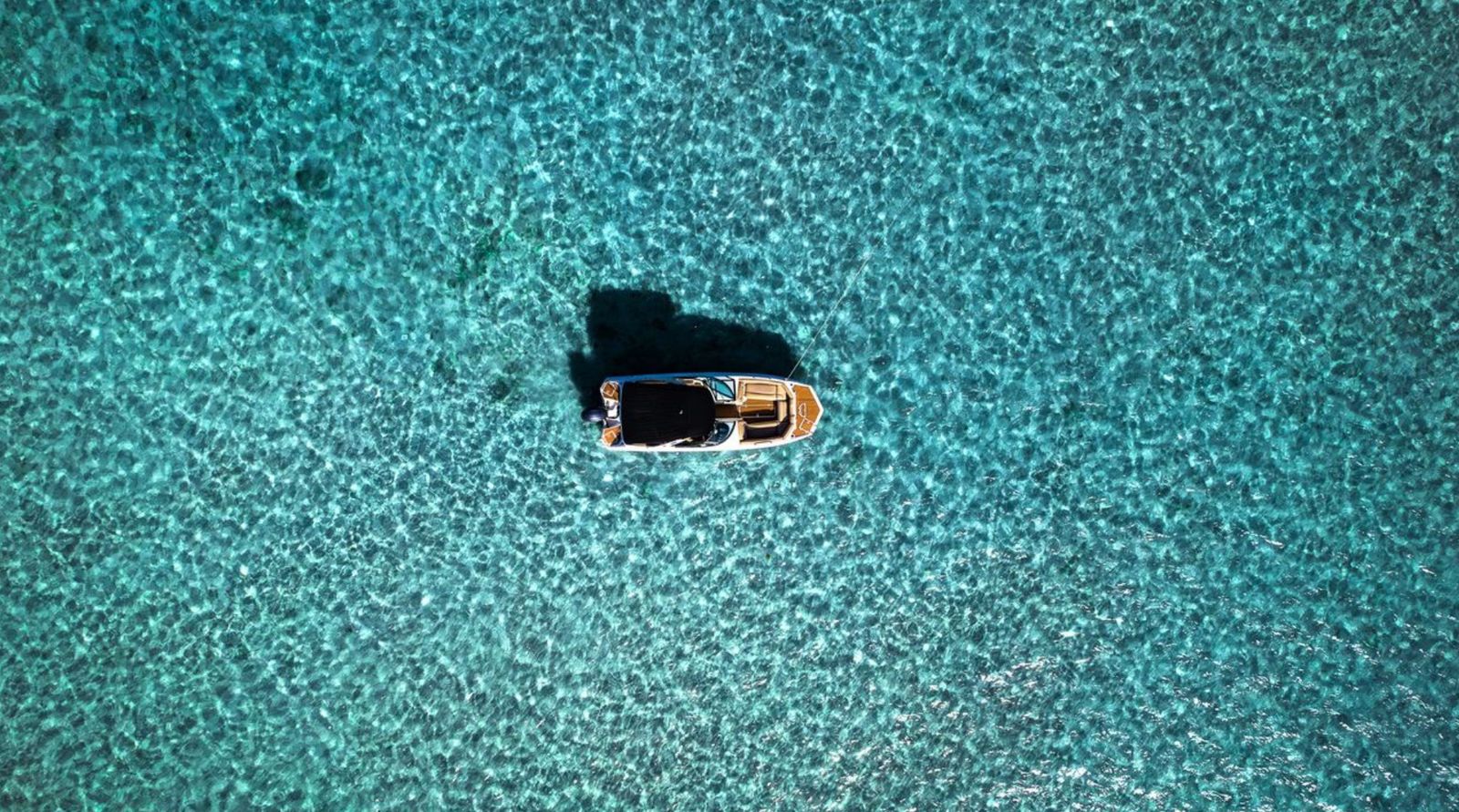 Aerial view of our boat anchored over a clear Miami sandbar