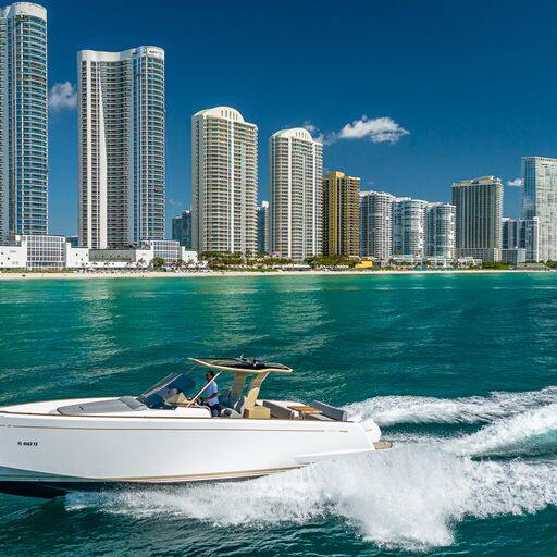 Private charter boat cruising Biscayne Bay past the Miami skyline and waterfront mansions
